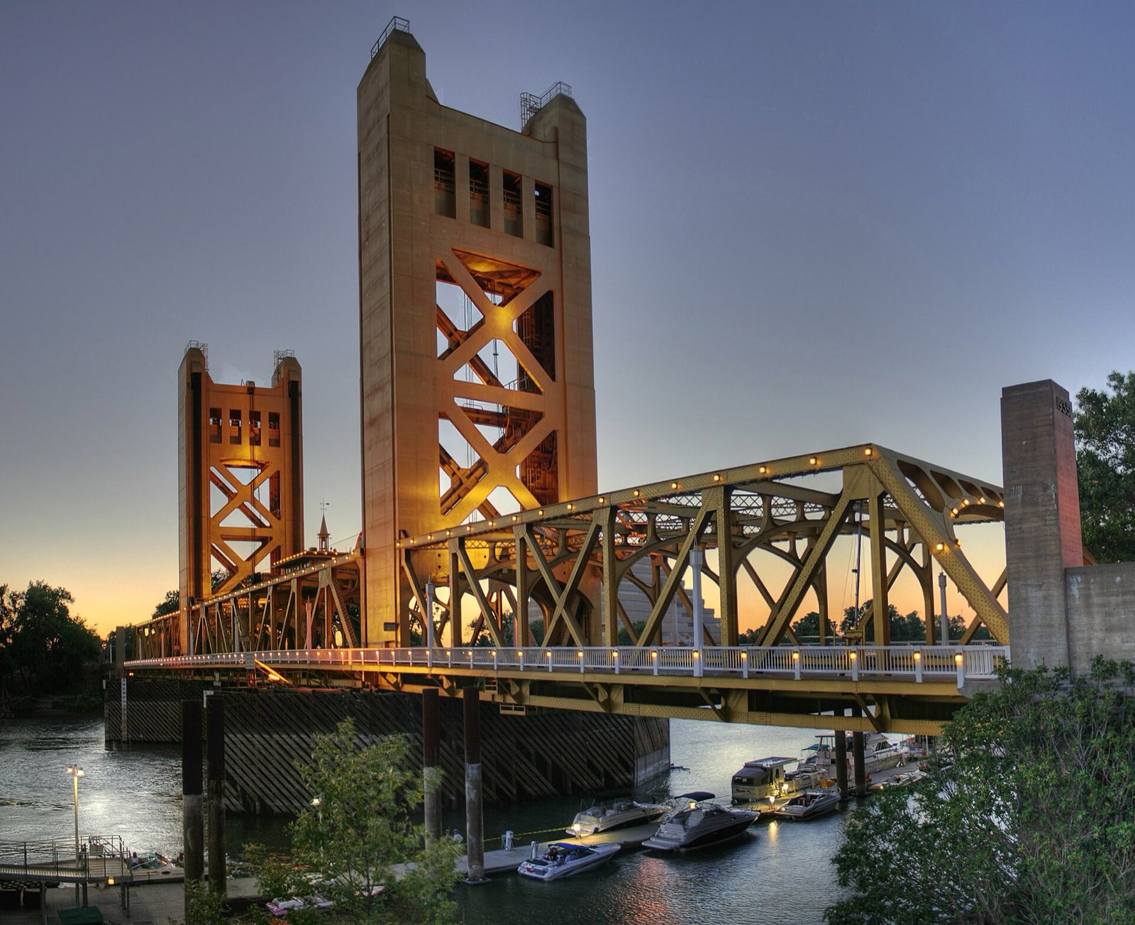 The gold Tower Bridge over the Sacramento River, seen from the east bank